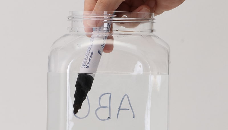 水に強い筆記具の透明の容器への使用例