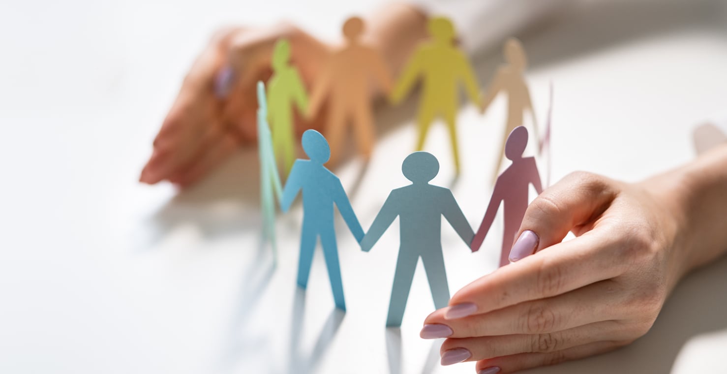 人々が手をつないでいる様子を紙で表現