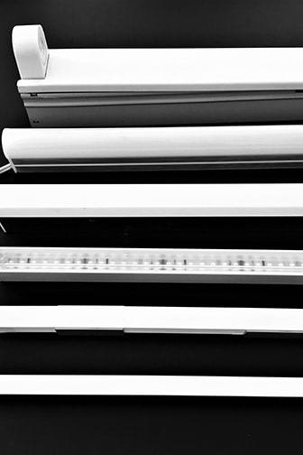 写真４　蛍光灯トラフ器具(左端とトップ)とおもなライン形LEDモジュールの大きさ比較